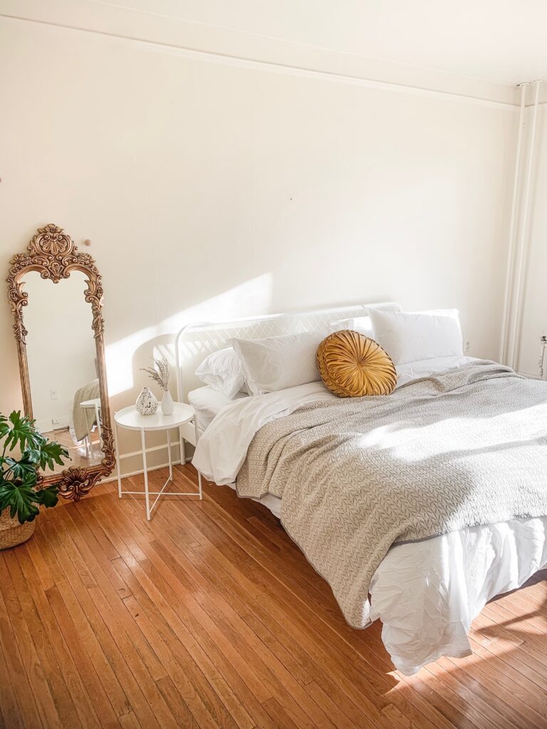 Simple Scandinavian bedroom with mirror and bed 