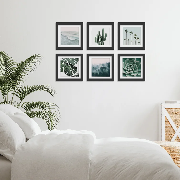 Scandinavian Bedroom with indoor plant, cosy blankets and pillows and six black frames photos