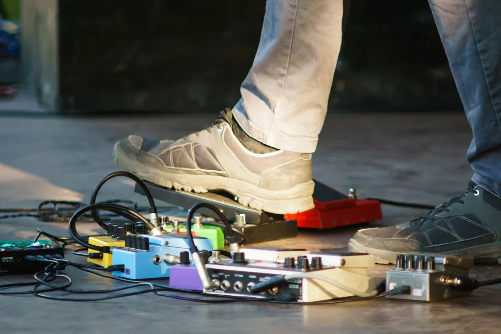 a man's foot on guitar pedals