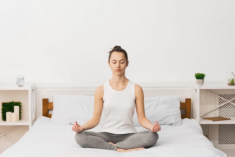 woman doing yoga on the bed